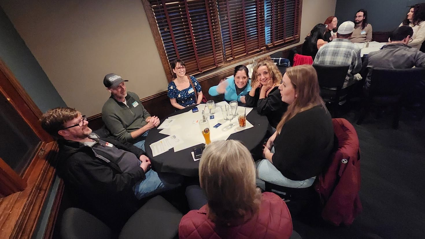 A group of attendees talking around a round table during a speed networking round