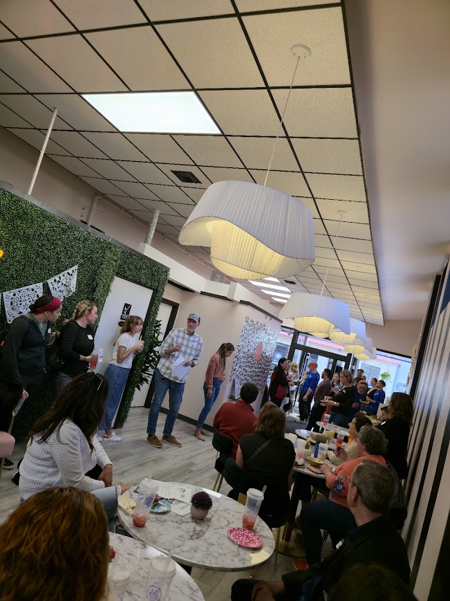 A host speaking to a full room of attendees at Idyllic Bubble Tea House