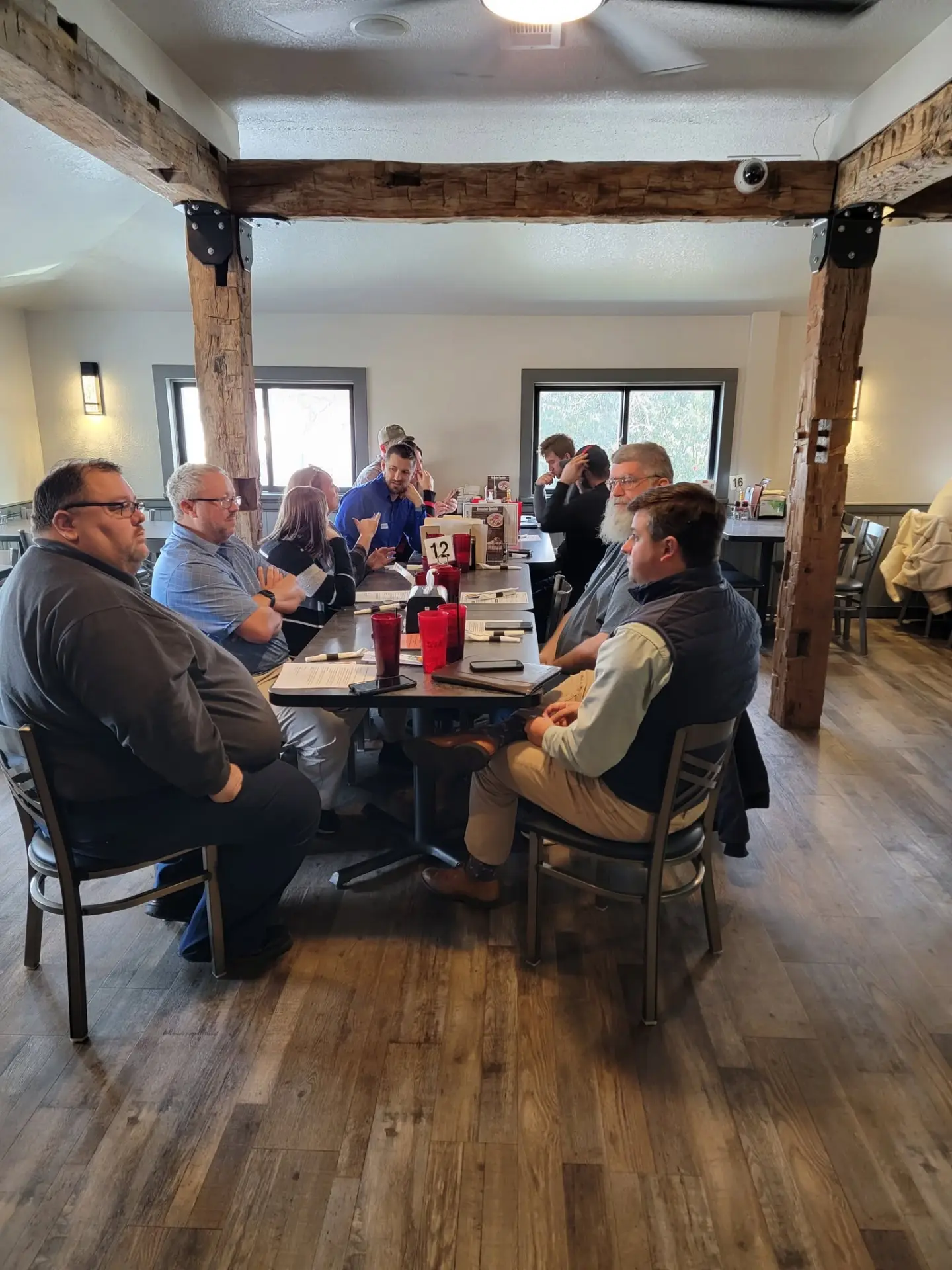 Attendees in conversation around a table at Uncle Larry's Rustic Inn
