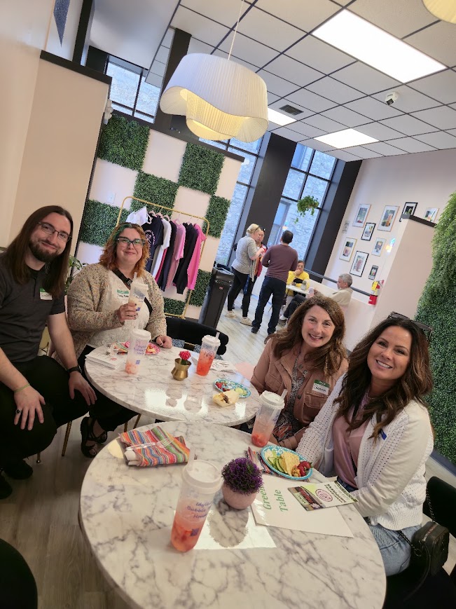 Four attendees chatting over bubble tea at a round table