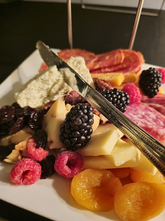 A charcuterie board of cheese, cured meats, berries and nuts served at a Local Social event