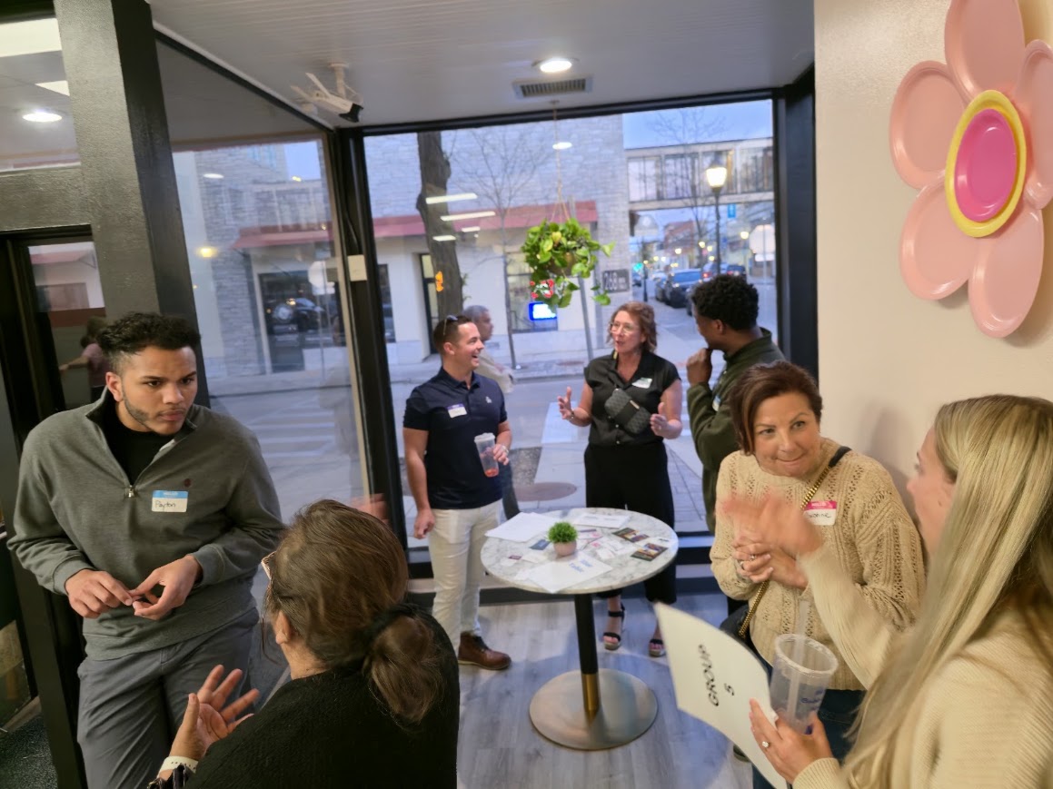 A small group of attendees talking near the front window