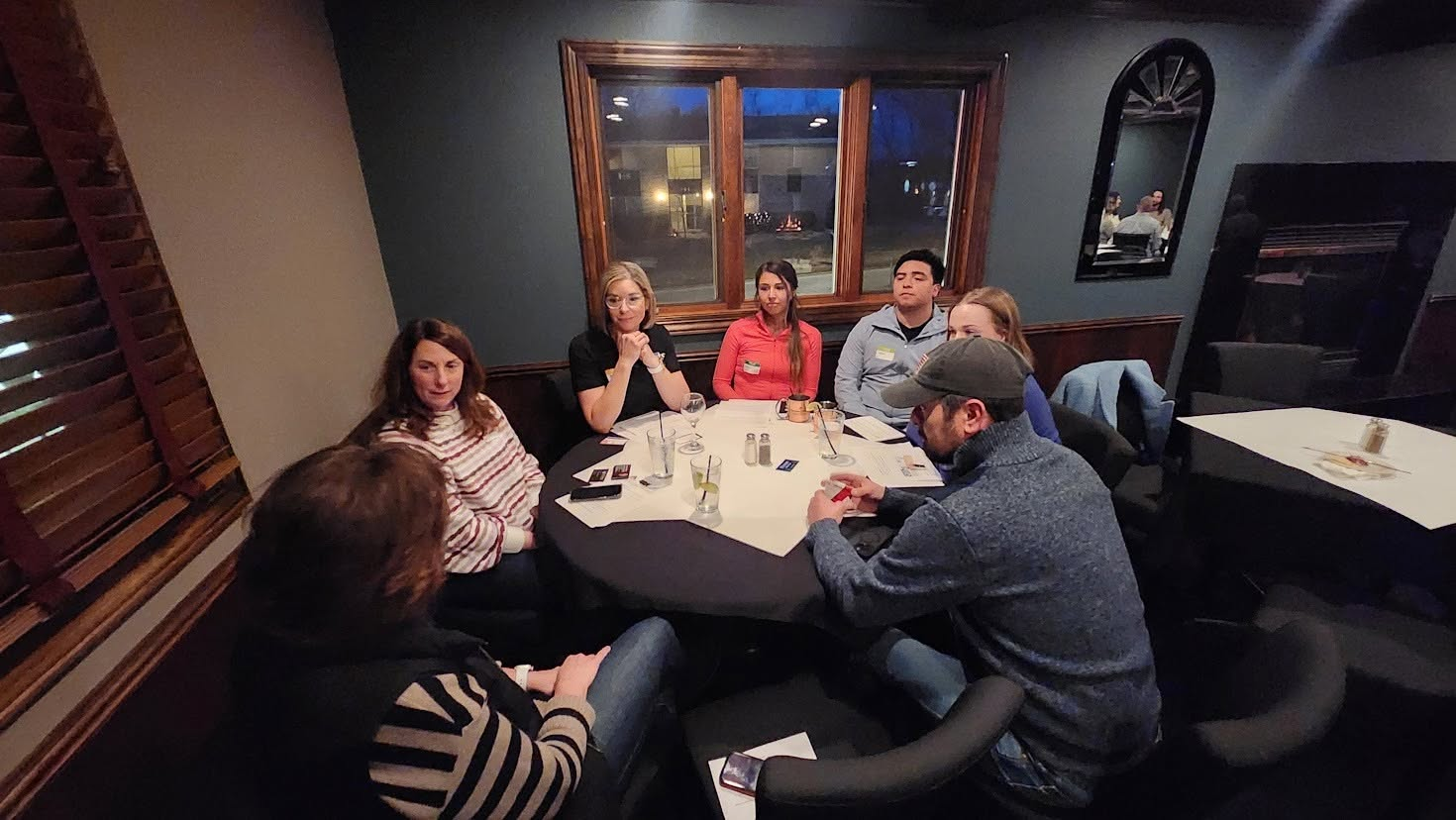 Six attendees in conversation around a table at the Butler Inn